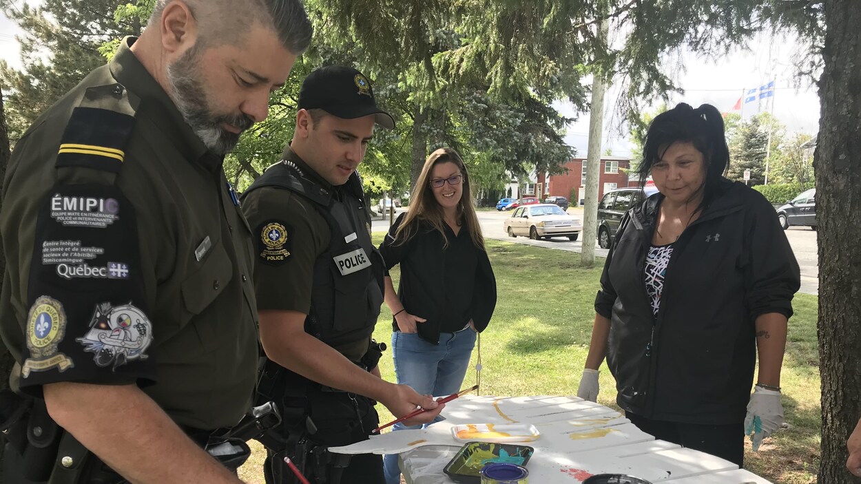 Des policiers du Poste de police communautaire mixte autochtone (PPCMA) de Val-d'Or participent à la confection de l'oeuvre collective au parc Bérard.