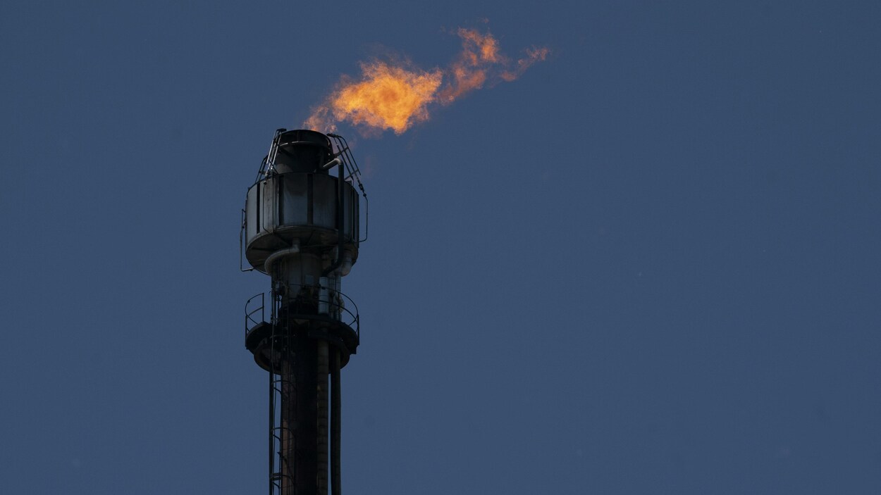Une flamme s'échappe d'une cheminée d'une raffinerie.