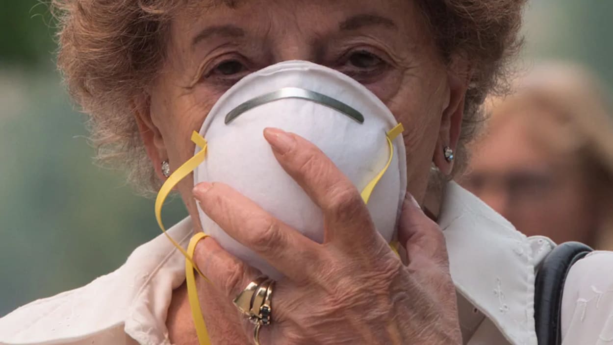 Une femme porte un masque pour se protéger de la pollution.
