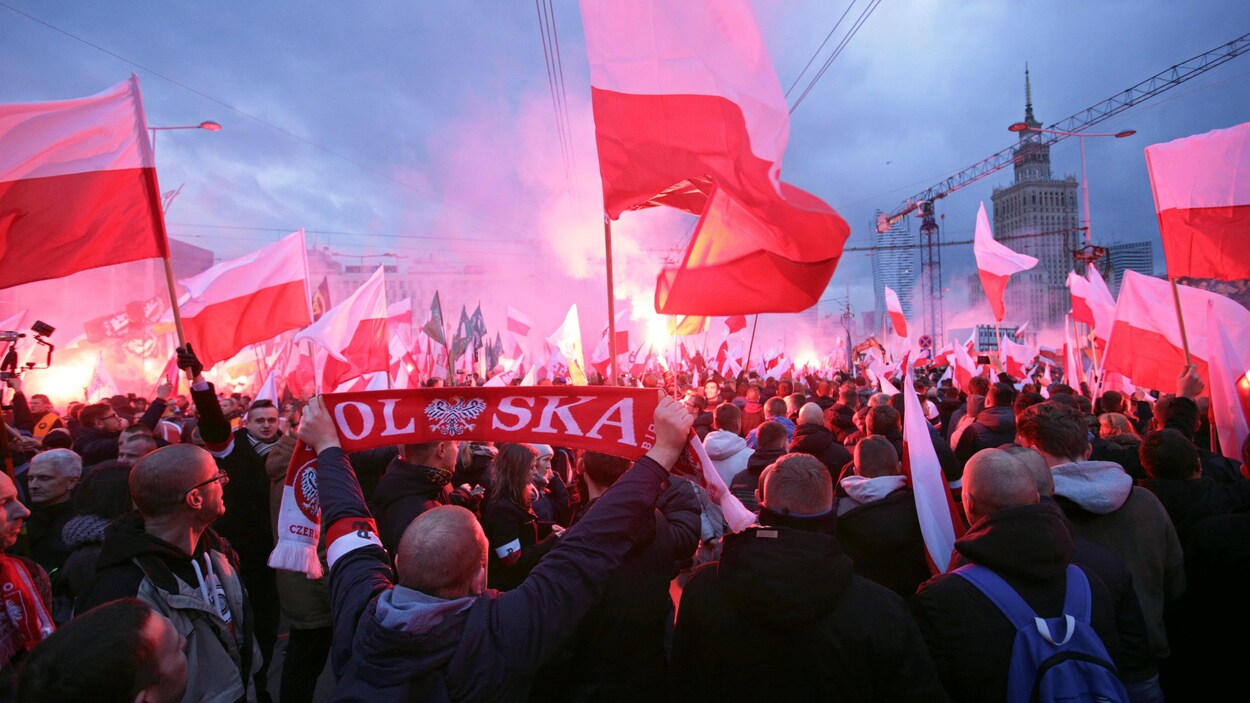 Des manifestants agitent des drapeaux polonais et des fumigènes dans une rue de Varsovie en Pologne. Des manifestants agitent des drapeaux polonais et des fumigènes dans une rue de Varsovie en Pologne.