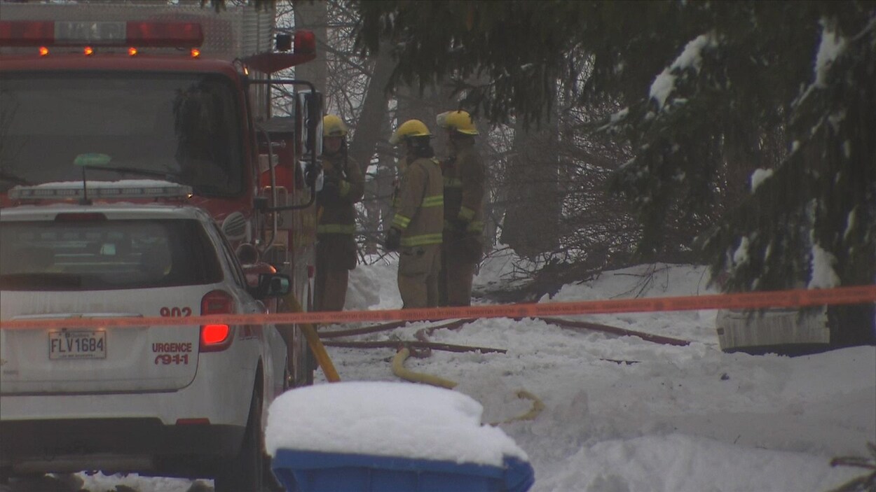 Des pompiers près de leur véhicule d'urgence.