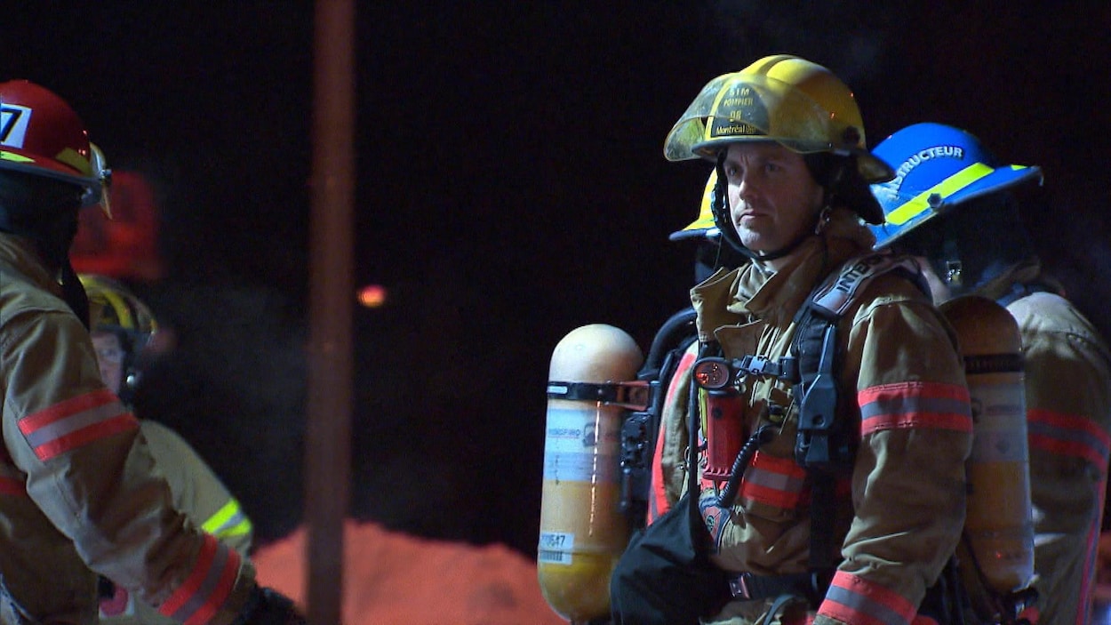 Des pompiers sont vêtus de leur équipement et attendent sur les lieux du brasier. Des pompiers sont vêtus de leur équipement et attendent sur les lieux du brasier.