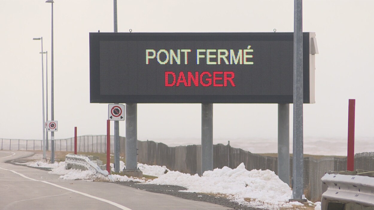 Une enseigne lumineuse à l'entrée du pont indique qu'il est fermé à cause d'un danger.