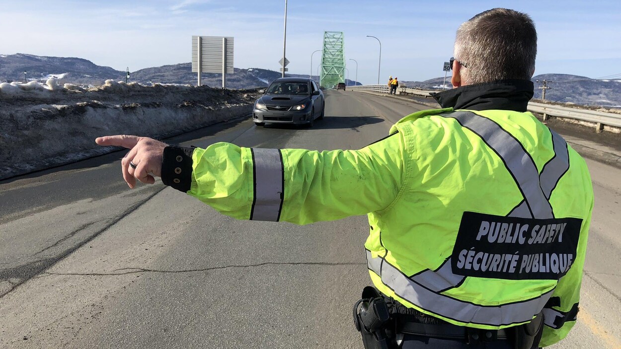 Un agent fait signe à un automobiliste.