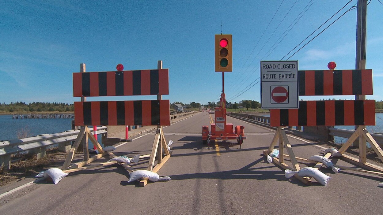 Panneaux routiers et feu de signalisation bloquant l'accès au pont.