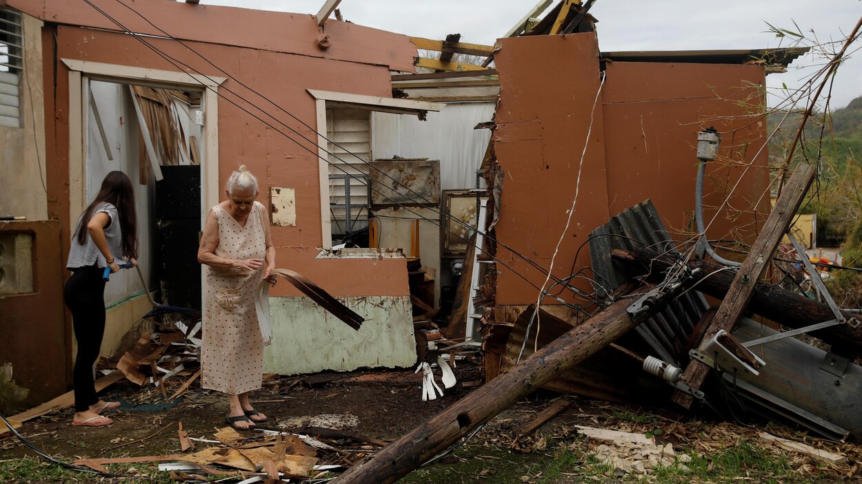 Deux femmes tentent de trier les débris de leur maison, réduite à l'état de ruines par l'ouragan Maria.