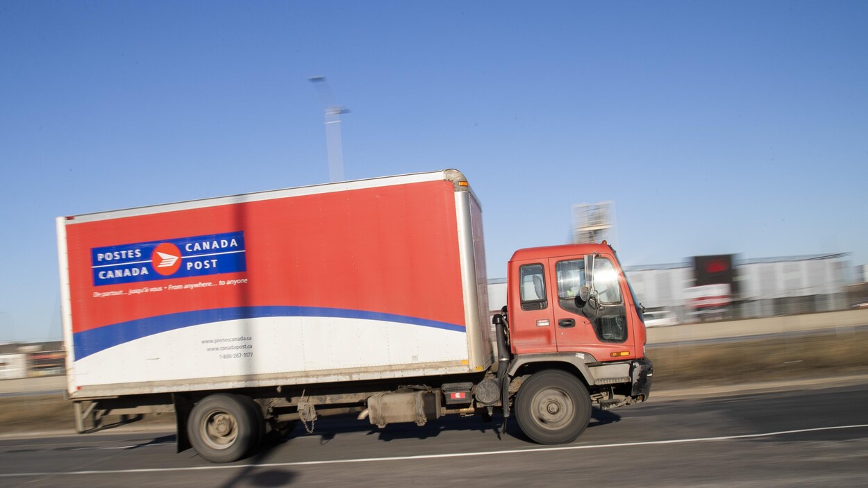 Un camion de Postes Canada circule sur l'autoroute.