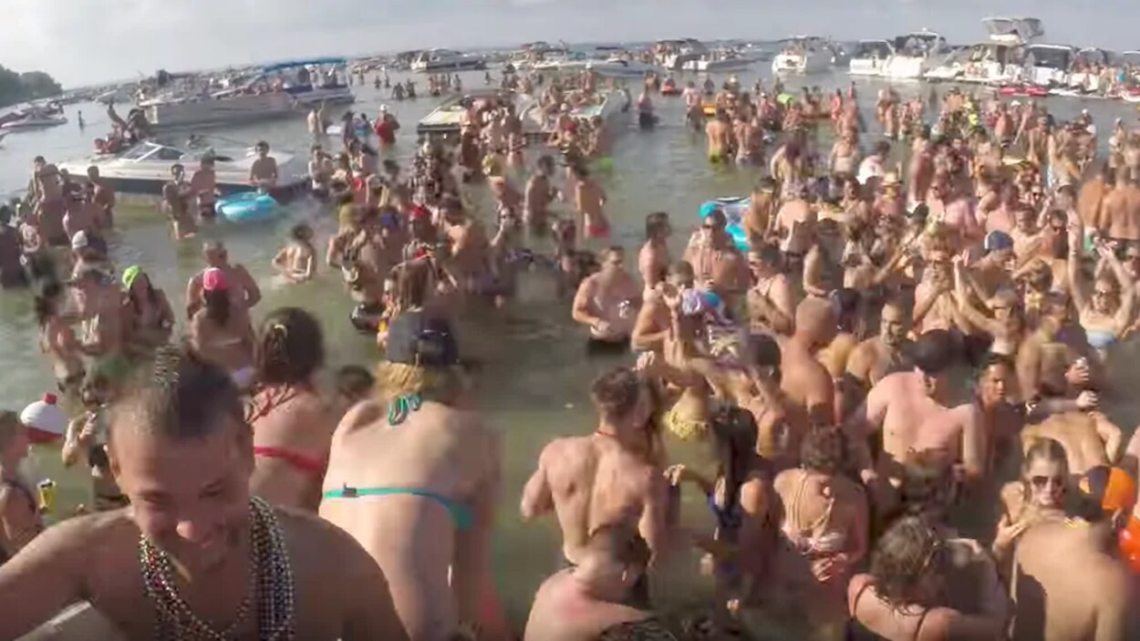 Des dizaines de personnes font la fête dans un lac, l'été.
