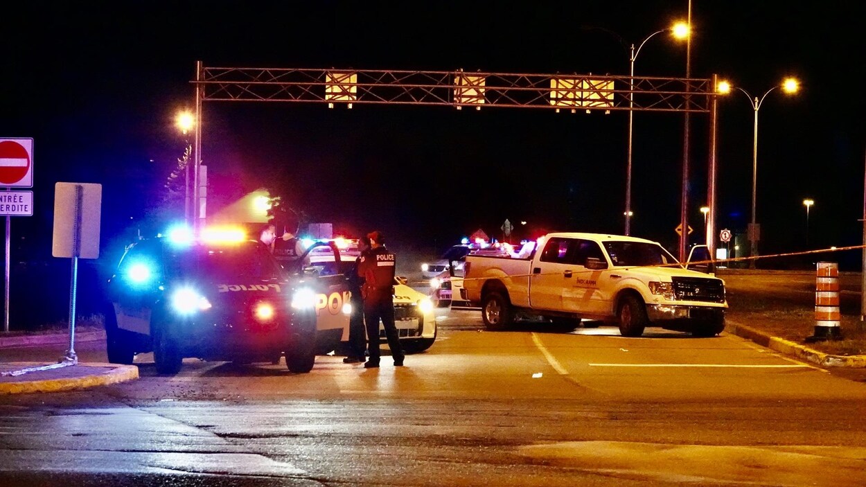 Des voitures de police et une camionnette accidentée, la nuit.