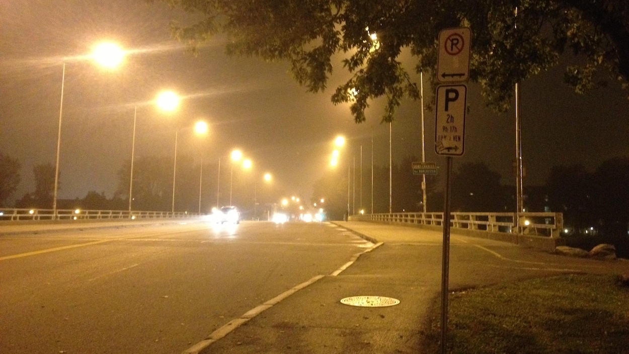 un pont routier avec des automobiles, la nuit, on voit un voile de grains dans l'air.