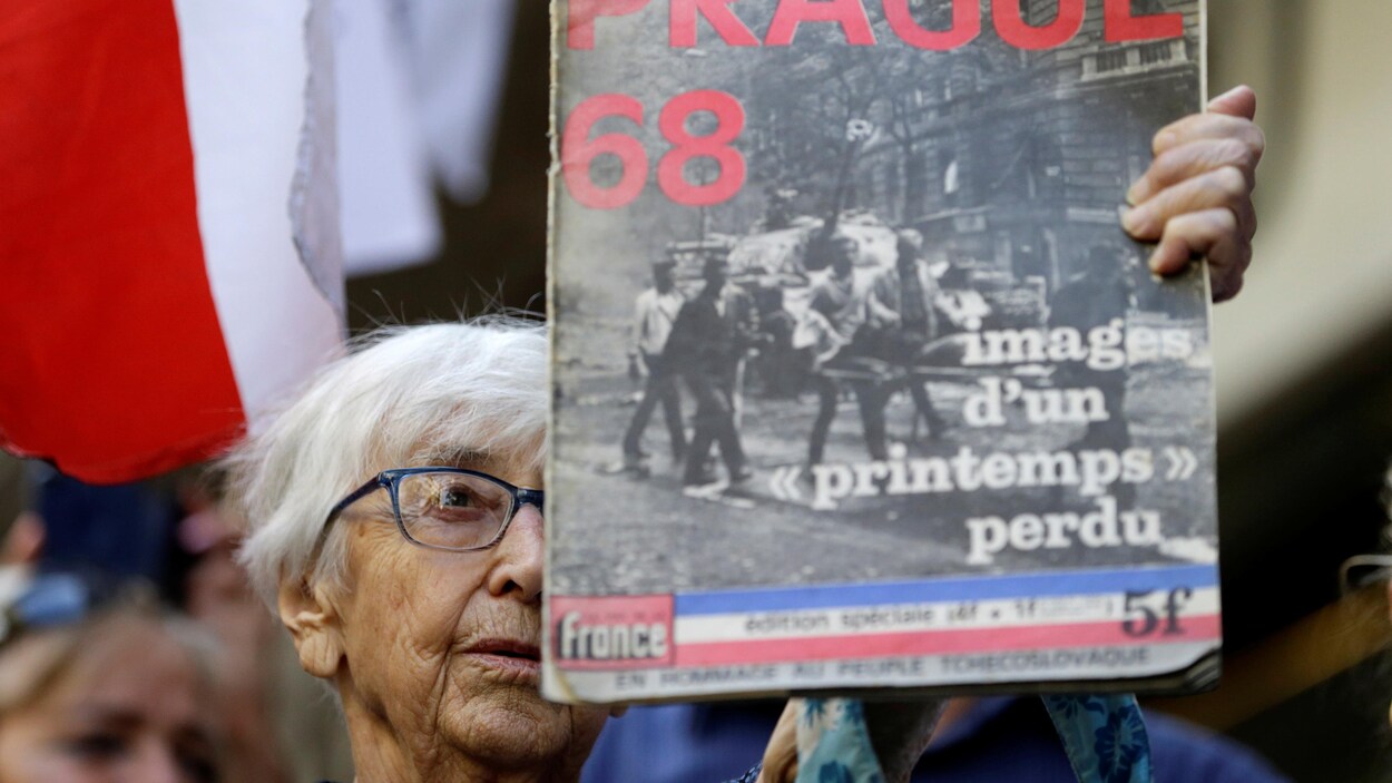 Une manifestante avec un magazine dans sa main.