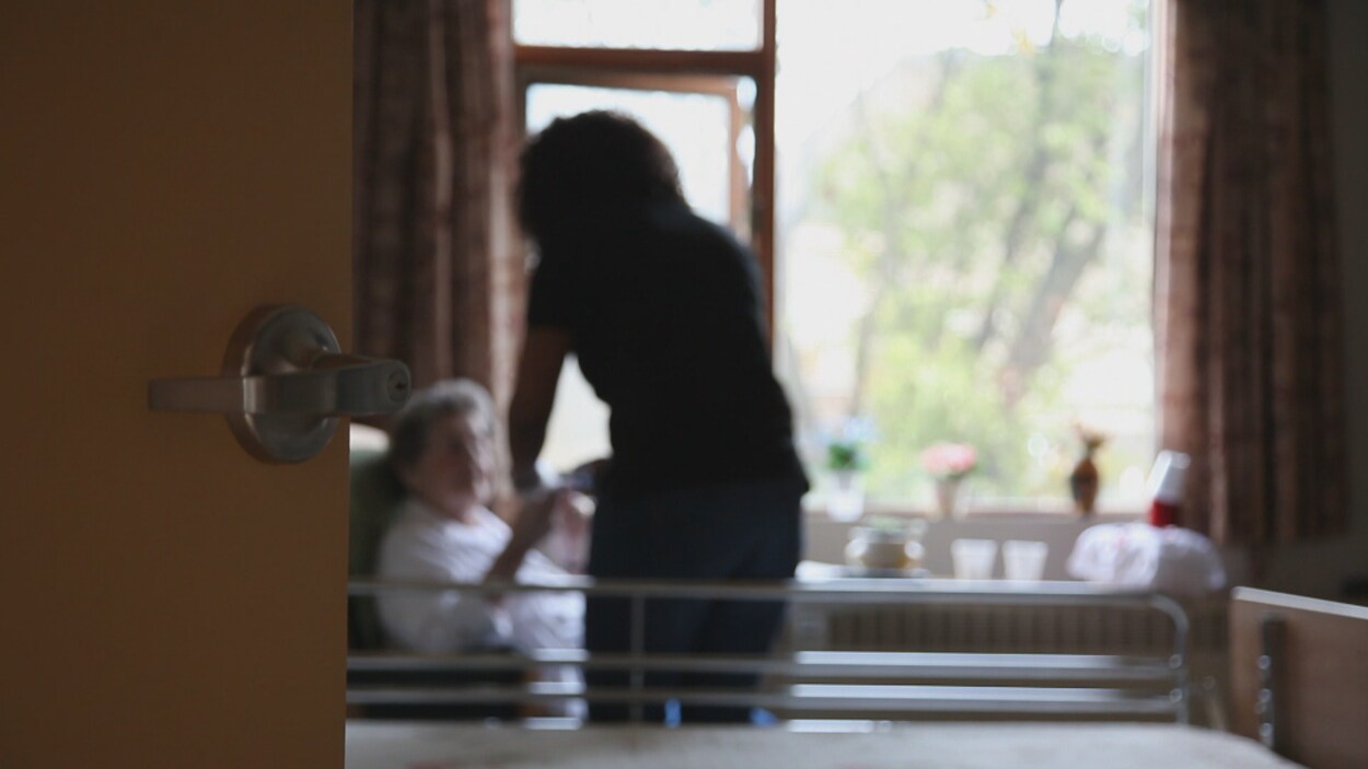 Une préposée aux bénéficiaires aide une patiente