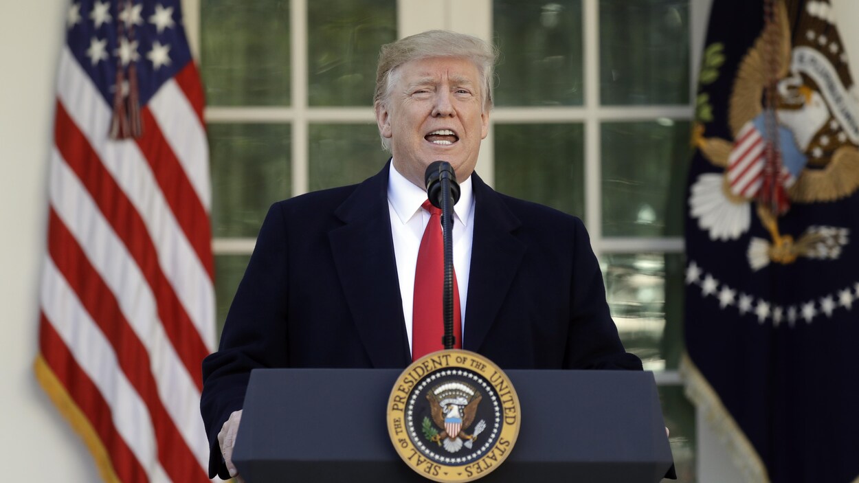 Donald Trump parle au micro derrière un podium portant le sceau présidentiel.