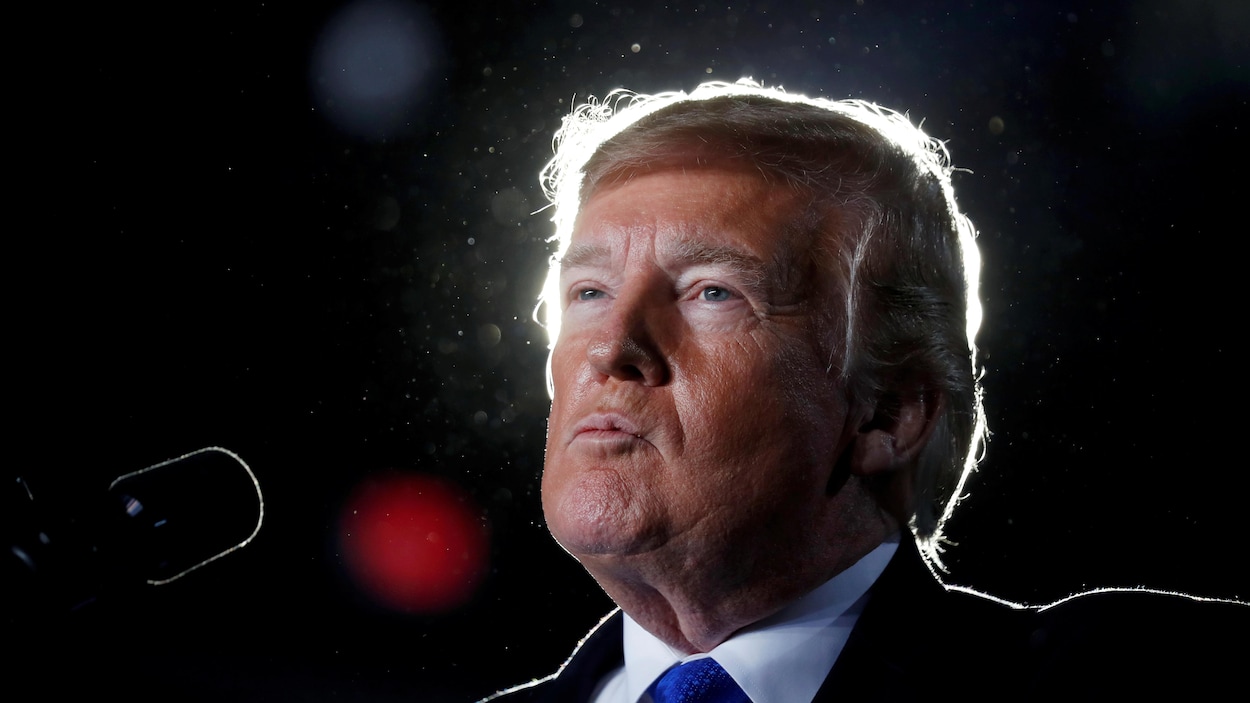 Plan rapproché de Donald Trump devant un micro, en conférence de presse.