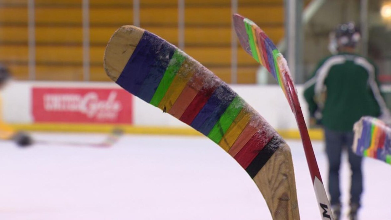 Un bâton de hockey est entourant d'un ruban multicolore.