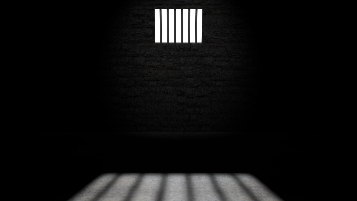 Intérieur d'une cellule de prison, une fenêtre laisse entrer la lumière