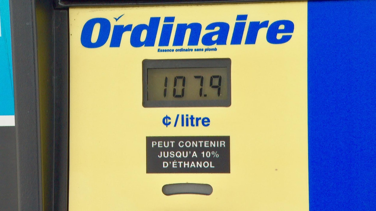 Une pompe d'essence ordinaire sans plomb qui indique le prix de 107,9 cents par litre.