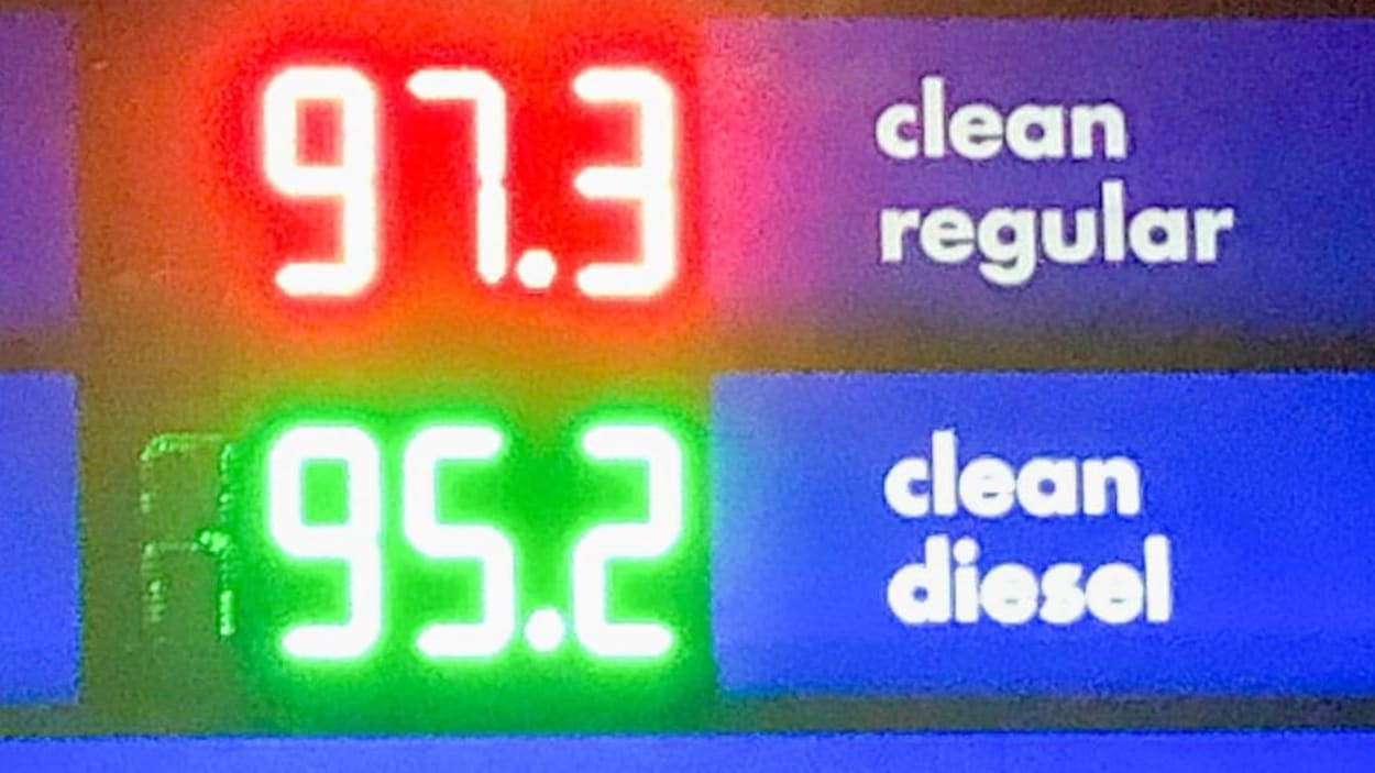 Une affiche indique le prix de l'essence à 97,3 sous le litre.