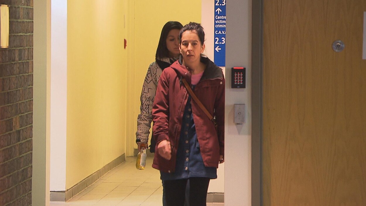 Deux femmes qui marchent dans un couloir du palais de justice.
