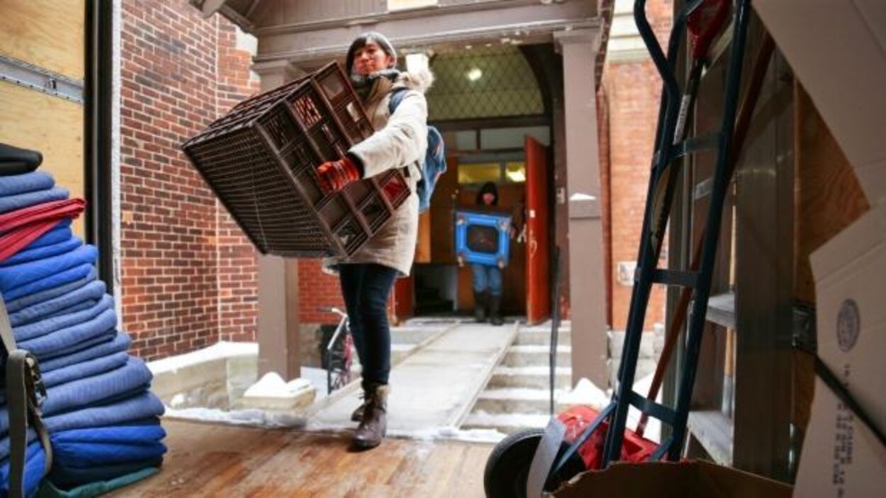 Une personne transportant un bac à l'intérieur d'un camion de déménagement Une personne transportant un bac à l'intérieur d'un camion de déménagement