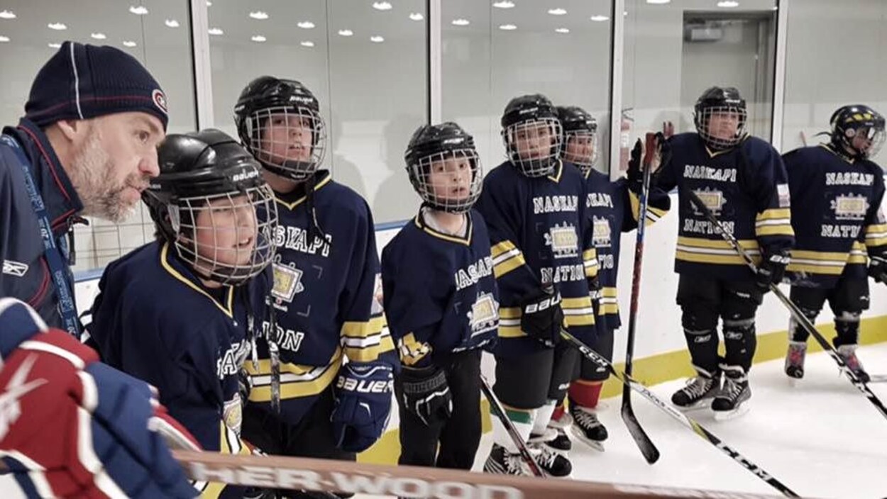 Joé Juneau donne ses instructions à de jeunes hockeyeurs de Kawawachikamach sur la patinoire locale. Joé Juneau donne ses instructions à de jeunes hockeyeurs de Kawawachikamach sur la patinoire locale.