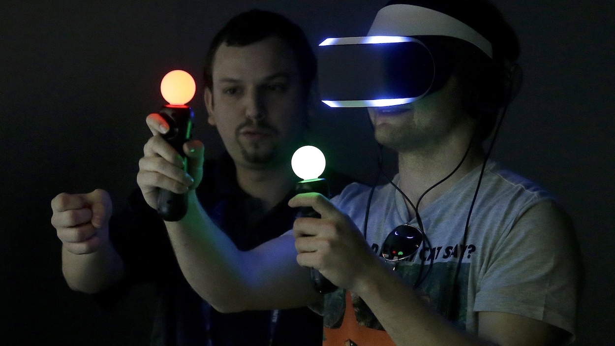 Un homme joue à un jeu en réalité virtuelle avec des manettes contrôlées par le mouvement.