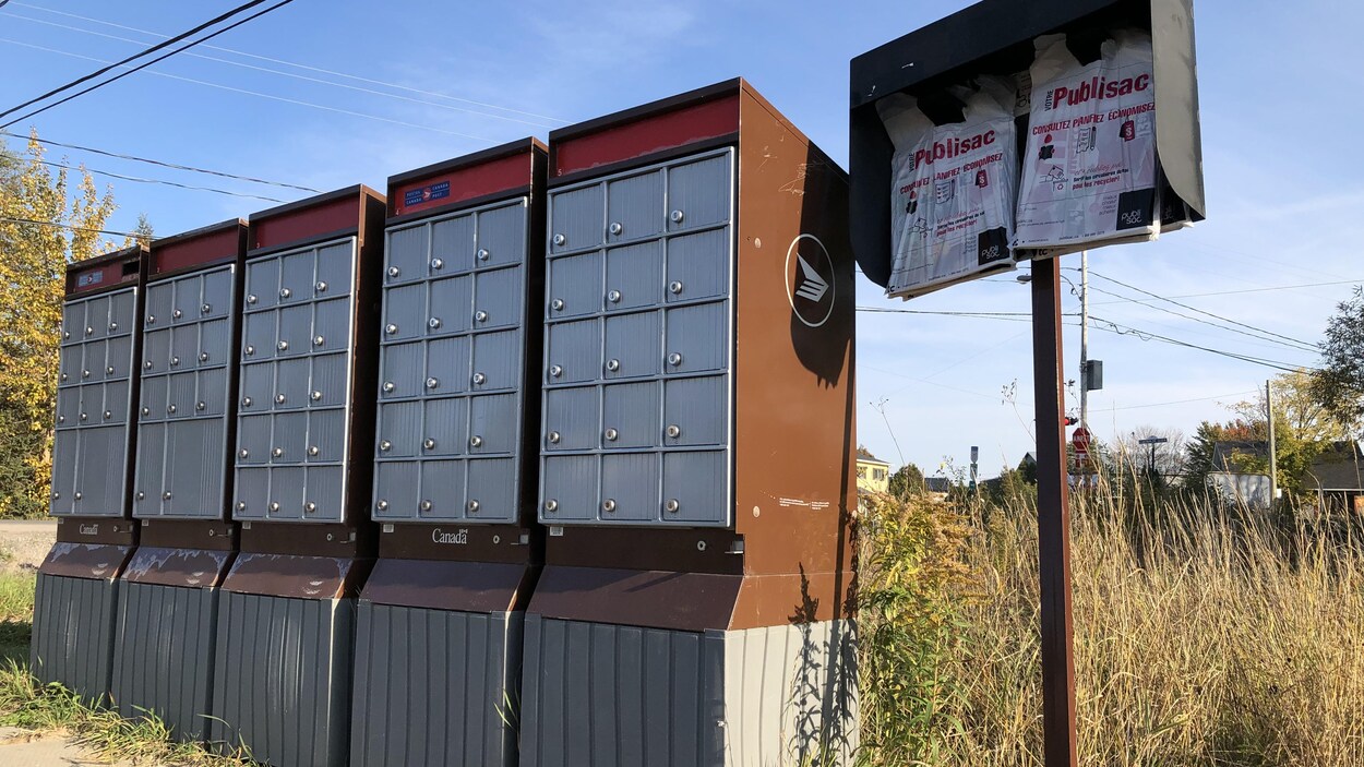 Des Publisac accrochés près d'une boîte postale.