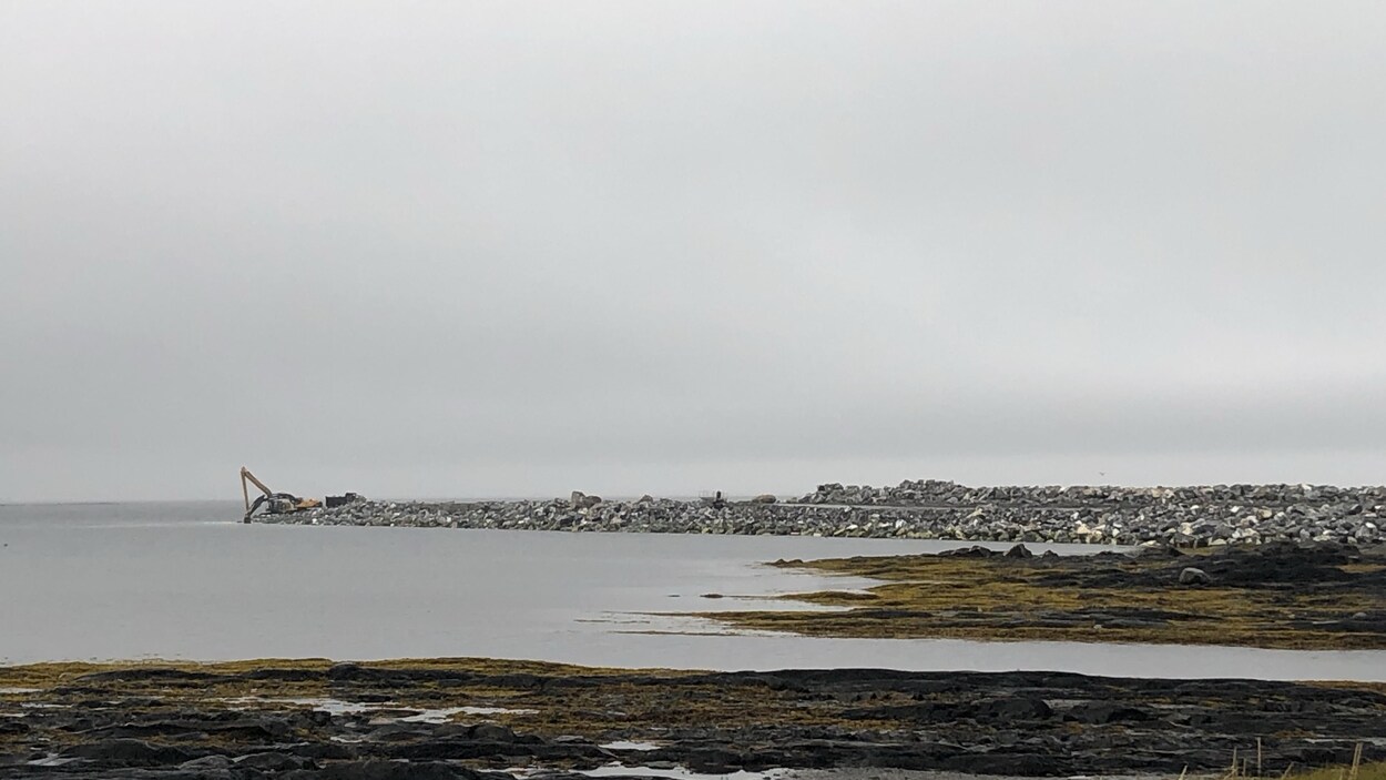 Un quai avec une grue et un camion au bout.
