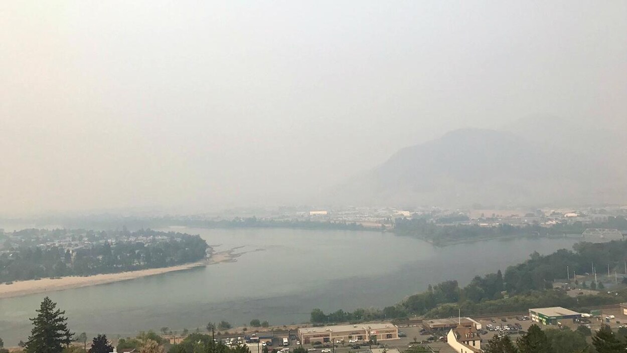 Une ville, une rivière et des montagnes sous un épais manteau de fumée Une ville, une rivière et des montagnes sous un épais manteau de fumée