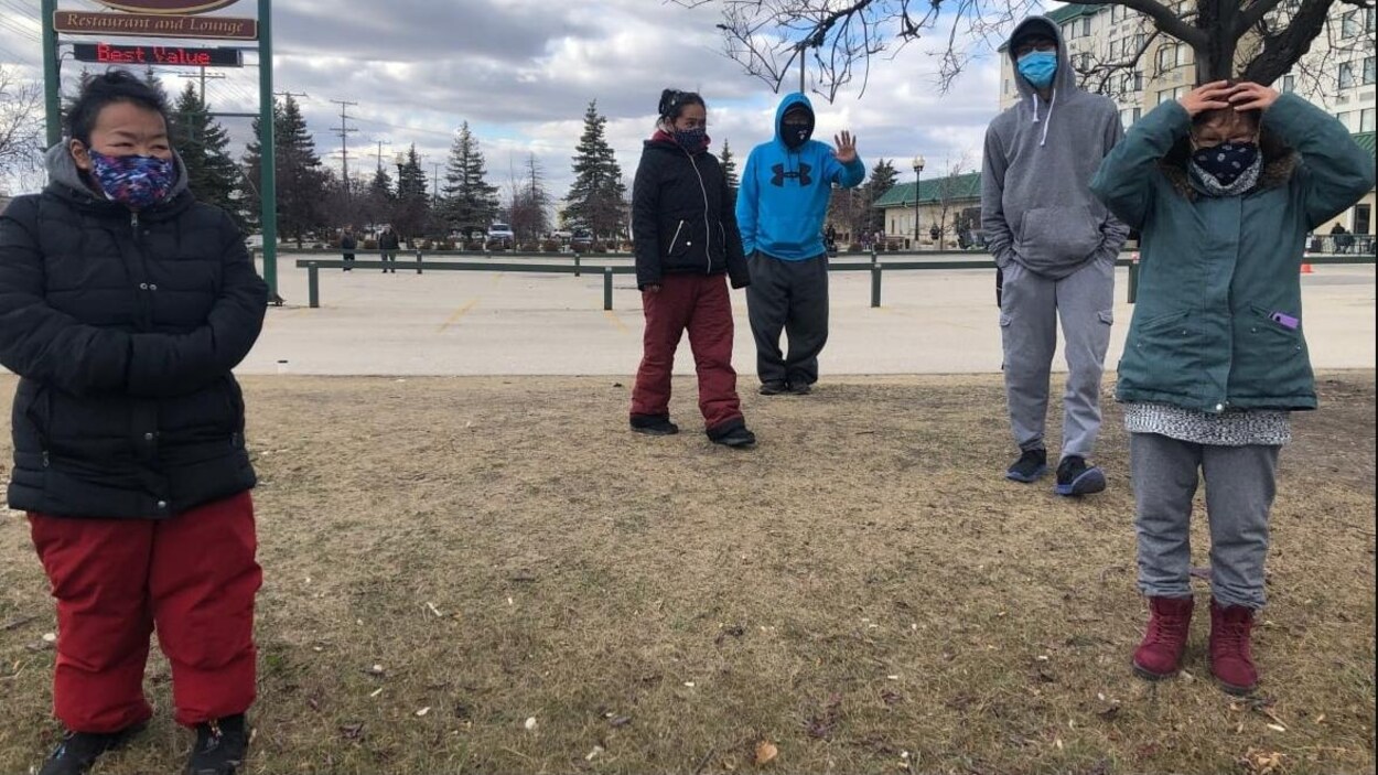 Des Inuit portant des masques sur un terrain.