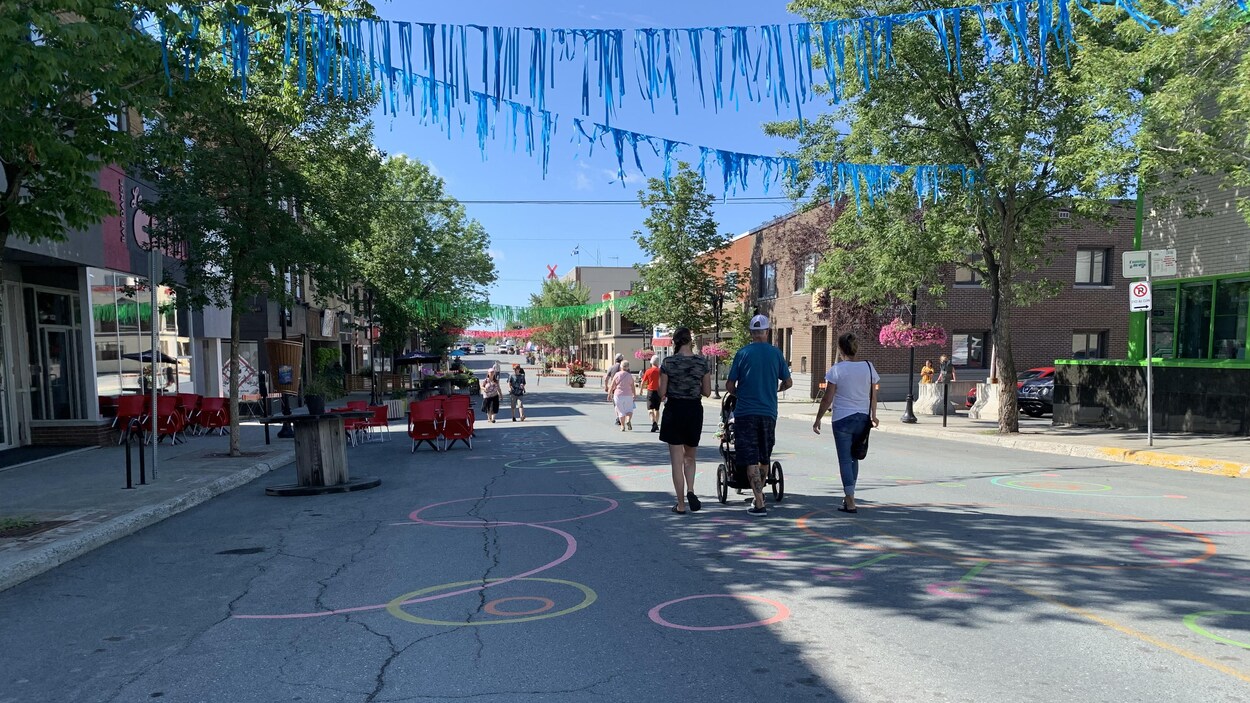 Des piétons marchent sur la rue Principale de Rouyn-Noranda, décorée.