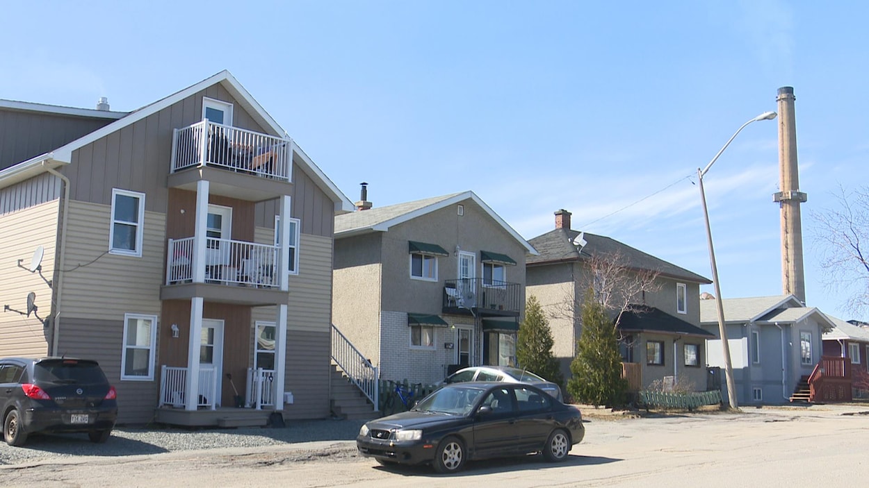 Des maisons du quartier Notre-Dame à Rouyn-Noranda, une cheminée de la Fonderie Horne en arrière-plan.