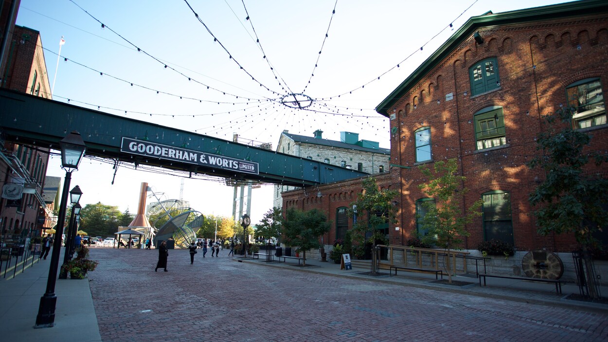 Quartier historique de la Distillerie à Toronto avec des bâtiments en brique rouge et des rues piétonnières en pavés.