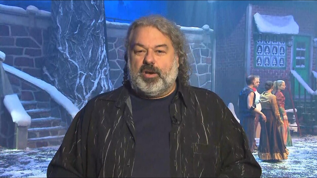 Un homme parle devant une scène.