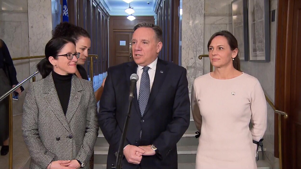 François Legault entouré de ses ministres Sonia LeBel et Isabelle Charest.
