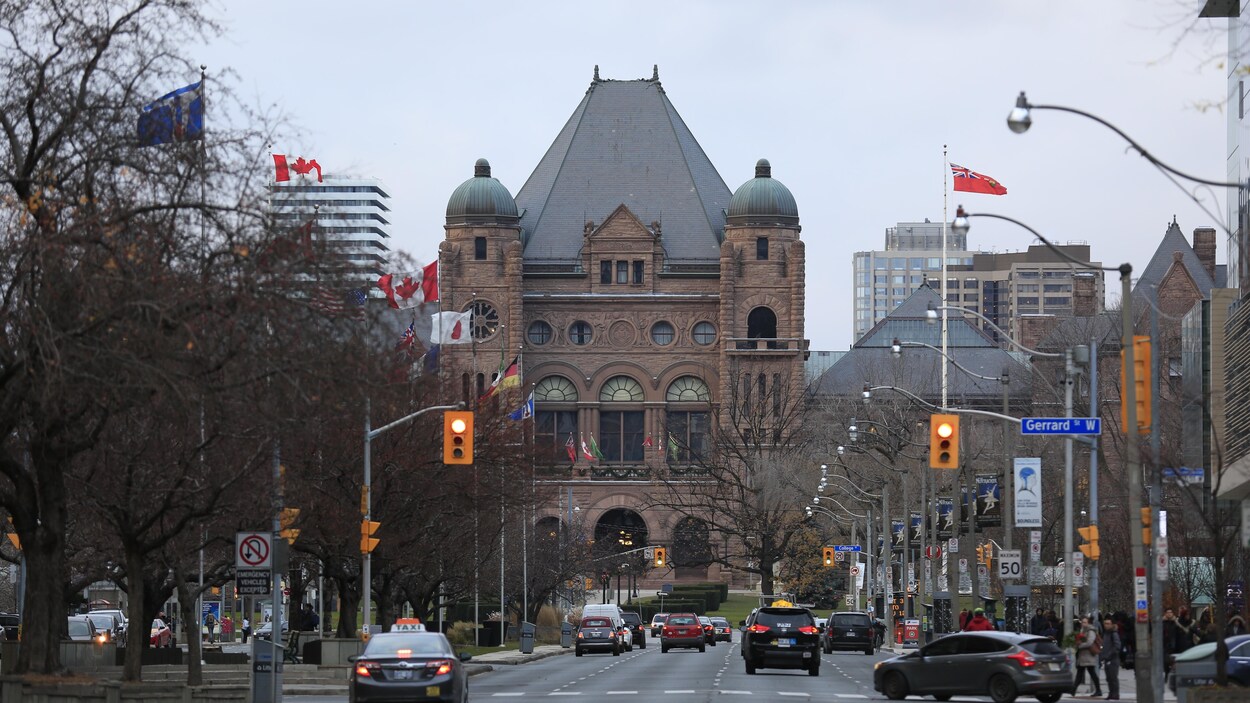 Le bâtiment du parlement ontarien de Queen's Park avec vue sur une rue de Toronto.