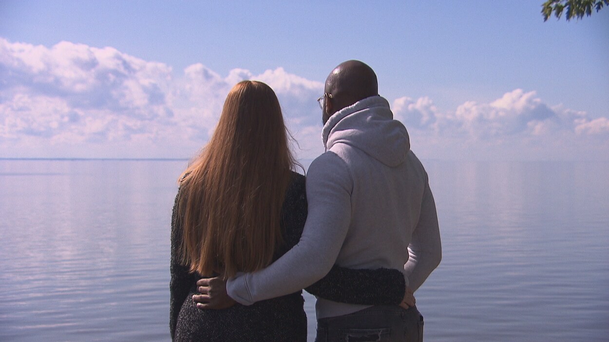 un couple, de dos, face au fleuve