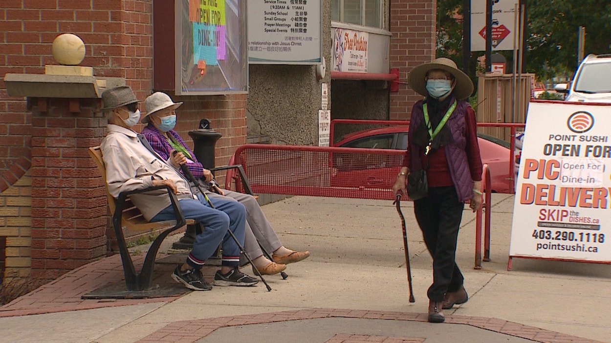 Trois personnes âgées d'origine chinoise dans la rue.