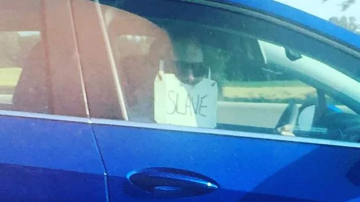 Un automobiliste porte une sorte de masque sur lequel on peut lire « esclave ».
