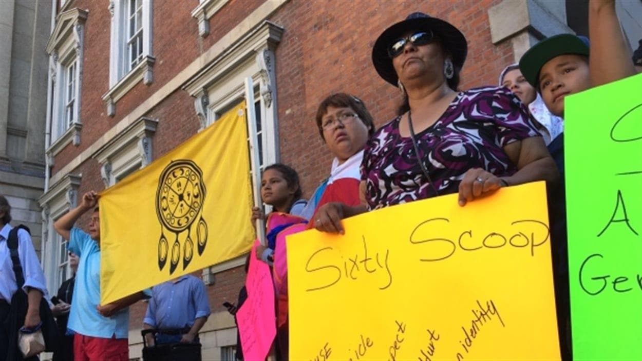 Des manifestants venus appuyer, en août 2016, le recours collectif contre le gouvernement fédéral pour son rôle dans la Rafle des années 1960 Des manifestants venus appuyer, en août 2016, le recours collectif contre le gouvernement fédéral pour son rôle dans la Rafle des années 1960