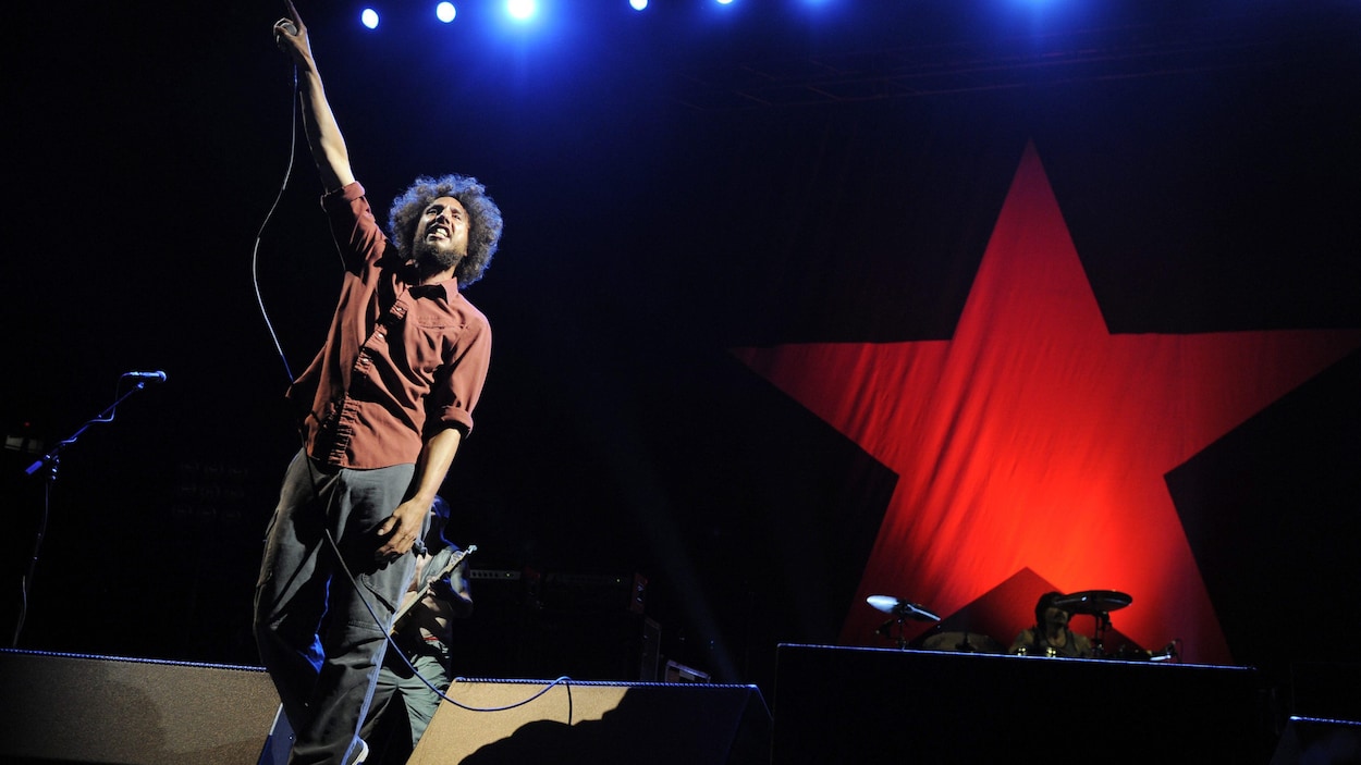 Le chanteur Zach de la Rocha lève le bras pendant un concert de Rage Against the Machine.