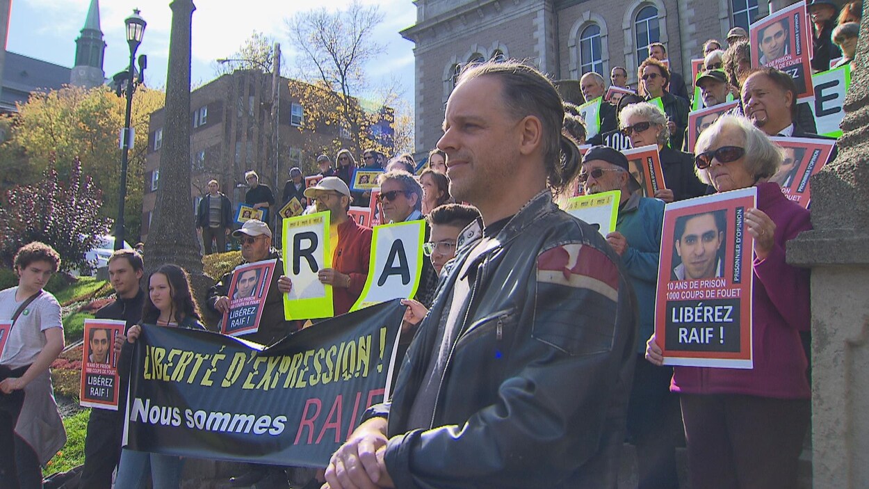 Des gens rassemblés devant l'hôtel de ville de Sherbrooke avec des affiches exigeant la libération du blogueur Raif Badawi.