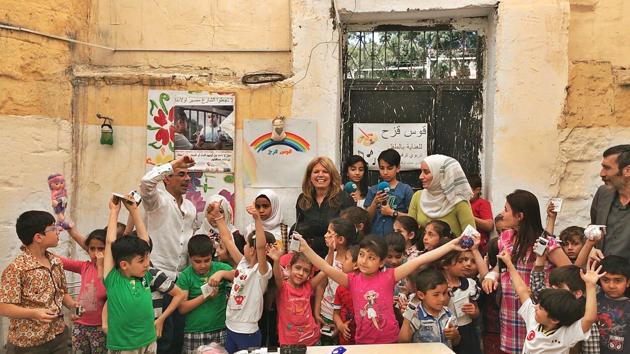 Les enfants réfugiés syriens lèvent les bras de joie après avoir reçu leurs radios. Les enfants réfugiés syriens lèvent les bras de joie après avoir reçu leurs radios.