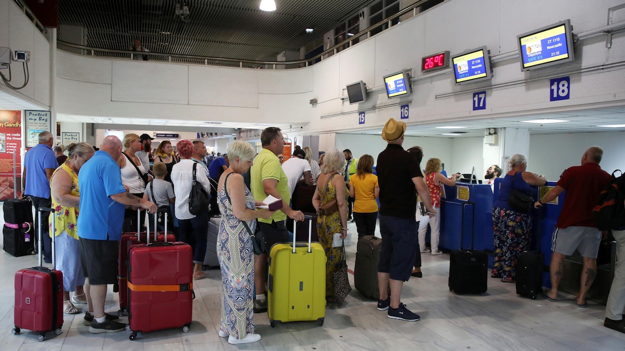 Des passagers devant les comptoirs Thomas Cook à l'aéroport d'Héraklion, sur l'île de Crète, en Grèce.