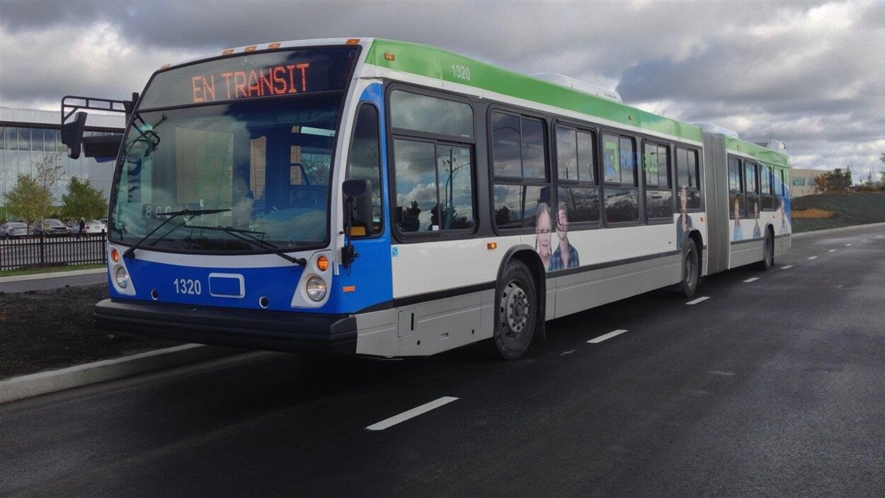 Un autobus de la STO qui circule sur une rue.