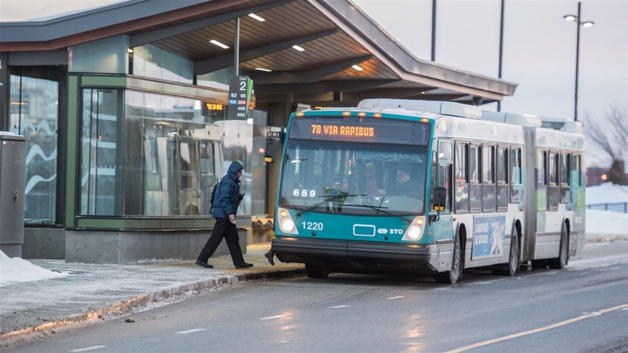 Un homme monte à bord d'un autobus.