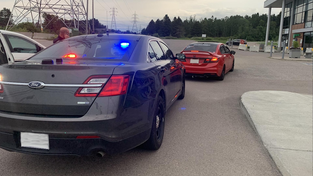 Un automobiliste arrêté dans le stationnement d'un commerce.