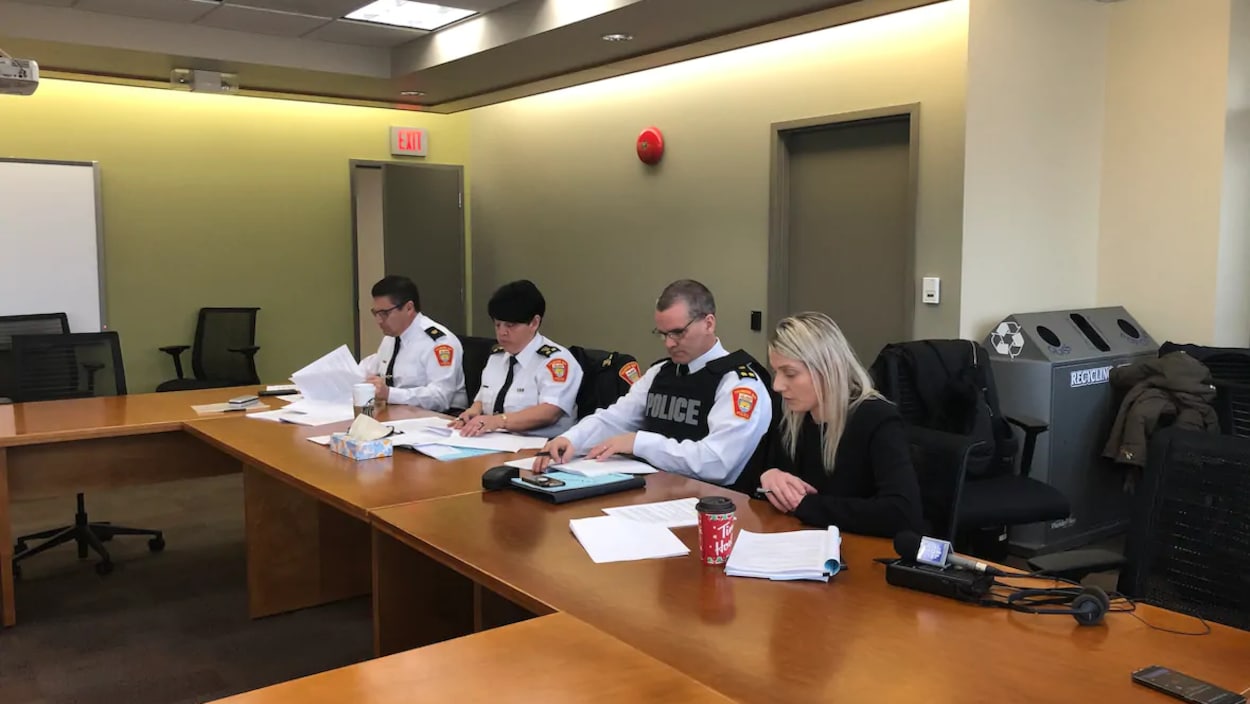 Holly Walbourne assise à une table en compagnie de trois représentants de la police de Thunder Bay, dont la chef, Sylvie Hauth.