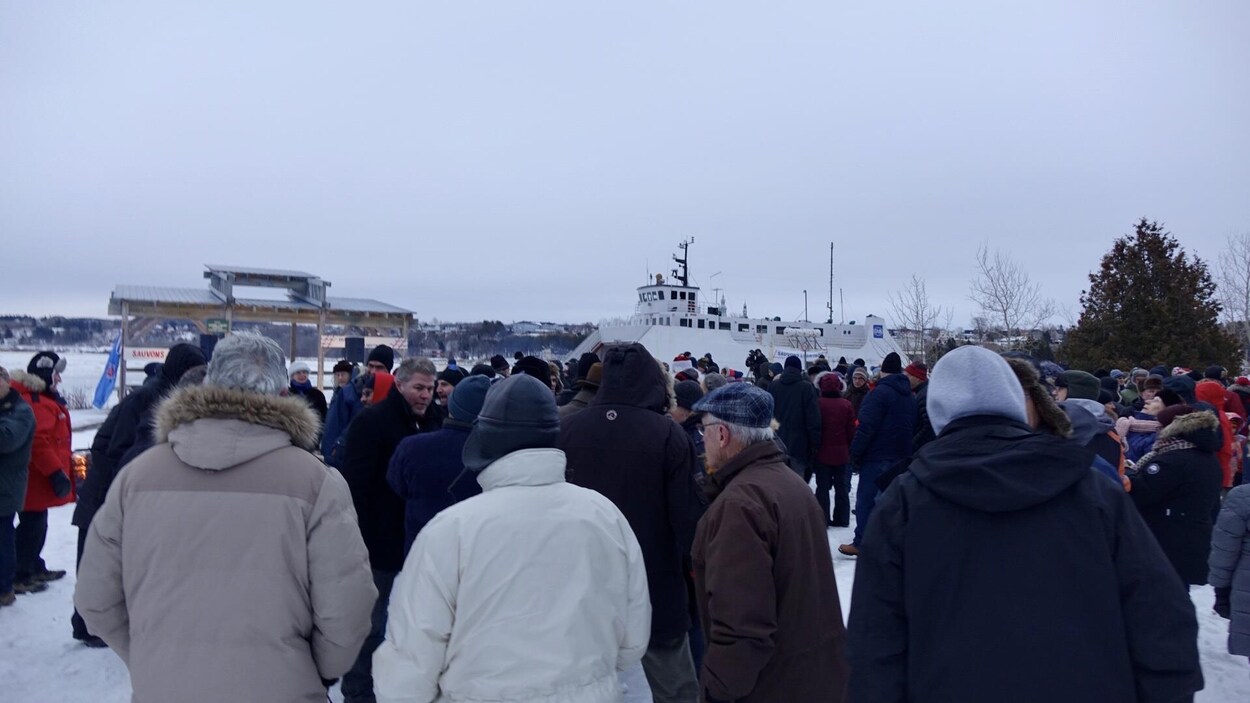 Beaucoup de monde avec le bateau en arrière-plan.