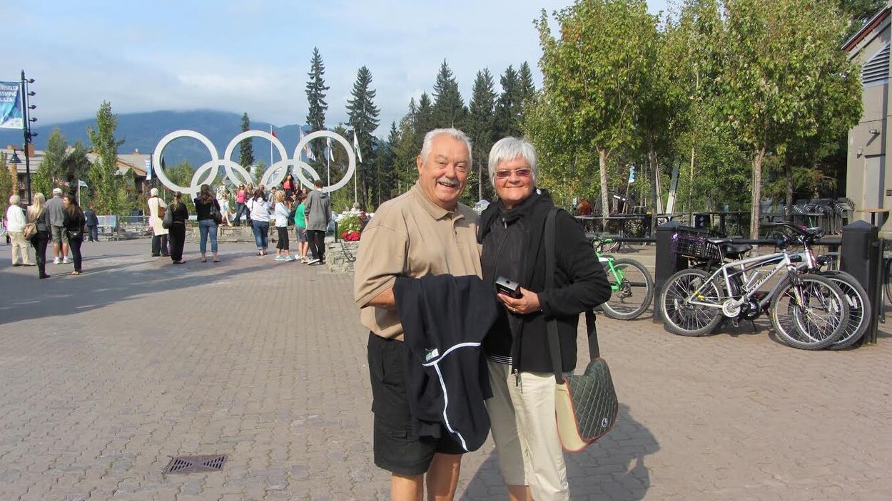 Raymon Bisson et Lorraine Bisson sourient devant les anneaux olympiques.